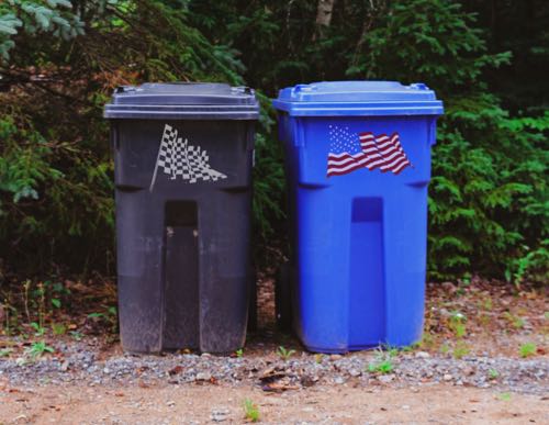 Checkered flag and American flag on garbage and recycling cans